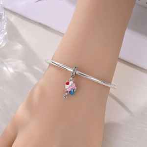 Detalle de una pulsera de plata con un colgante de esmalte de cono de helado arcoíris