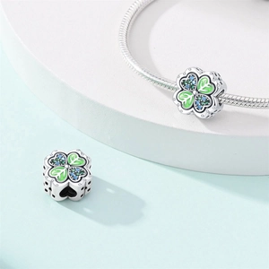 Detail of four-leaf clover charm with green enamel, colorful crystals and hollow hearts