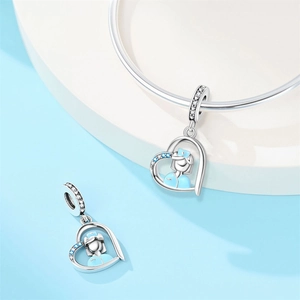 Macro detail of silver heart charm with nurse figure and sparkling blue zircons