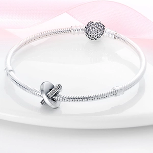 Détail macro du bracelet maille serpent argenté avec fermoir serti de cristaux et charm