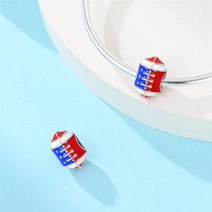 Macro detail of silver American football charm with red, white, and blue enamel on bracelet