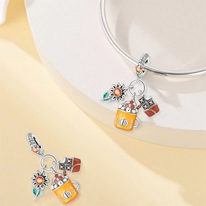 Detail of autumn jewelry charms with sunflower cup and pumpkin maple leaf enamel charms