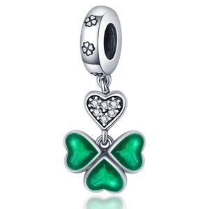 Macro detail of silver clover charm with green enamel petals and zircon heart
