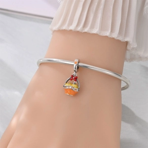 Detailed view of silver charm bracelet featuring autumn basket pendant with crystals