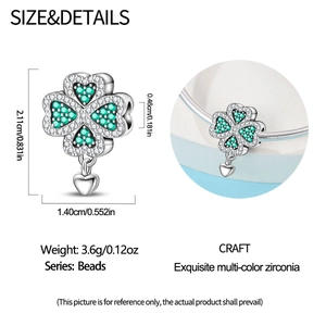 Detailed view of silver clover charm with green zircons and small heart pendant