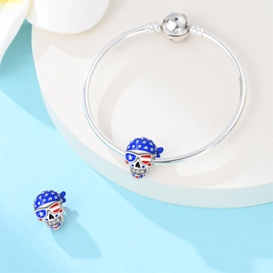 Detailed view of silver snake chain bracelet with American flag skull charms