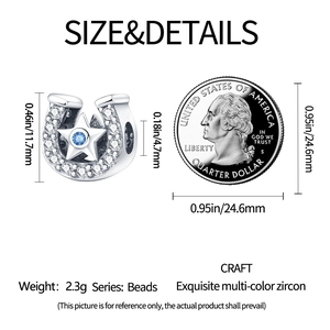 Macro shot of horseshoe charm with blue zircon star and dimensions next to a US quarter