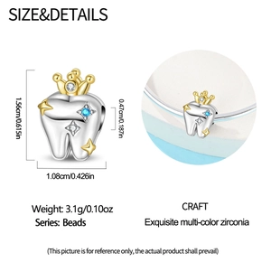 Detailed view of silver tooth charm with gold crown and multicolor cubic zirconia