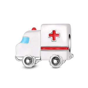 Macro shot of silver ambulance charm with white enamel and red medical cross detail