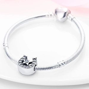 Macro shot of horseshoe charm with blue star crystal on silver snake chain bracelet