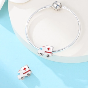 Detail of silver ambulance charms with red cross and white enamel on charm bracelet