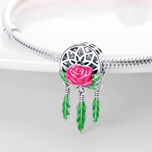 Detaillierte Makroansicht des versilberten Traumfänger-Charms mit rosa Rose und grünen Federn