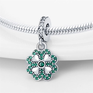 Vue macro d'un pendentif trèfle en argent avec zircons verts sur chaîne serpent