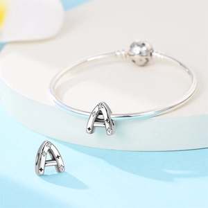 Macro view of silver letter A charm with cubic zirconia star on a tube bracelet