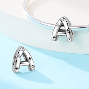 Macro detail of silver charm letter A with black star patterns and zircon for DIY bracelets