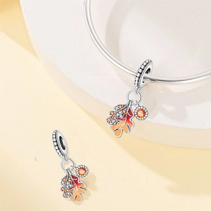 Macro detail of maple leaf pendant with orange gradient enamel and sparkling crystals