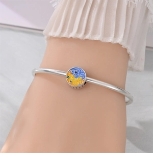 Close-up of silver bangle with Starry Night style enamel charm and colorful crystals