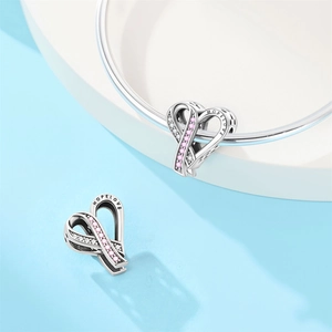 Close-up of heart charm with pink stones and Hope Love engraving on silver bead