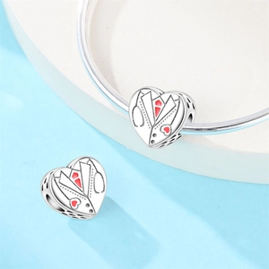 Macro view of silver heart charms with stethoscope and red enamel heart on charm beads