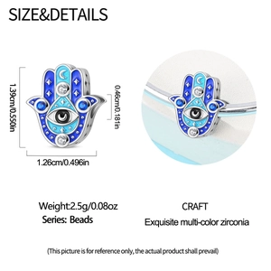 Detailed view of silver Hamsa charm with blue enamel eye and cubic zirconia accents
