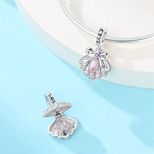 Macro view of shell charm with bow and gems, showing open and closed states