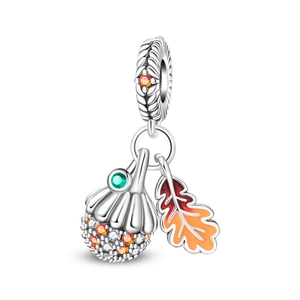 Macro detail of acorn and maple leaf charm with colorful cubic zirconia and enamel