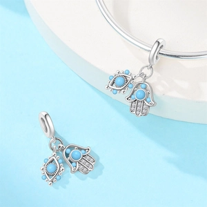 Macro detail of silver Hamsa Hand and Evil Eye charm with blue beads for bracelets