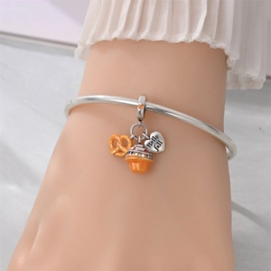 Close-up of fall charms including pumpkin and Hello Fall heart on silver bracelet