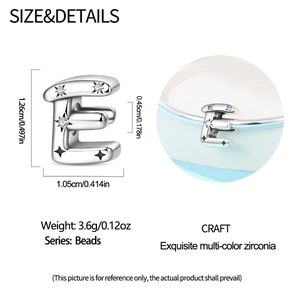 Macro detail of silver letter E charm bead with zircon inlay and star relief pattern