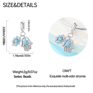 Detail view of silver Hamsa Hand and Evil Eye charm with blue stone and cubic zirconia