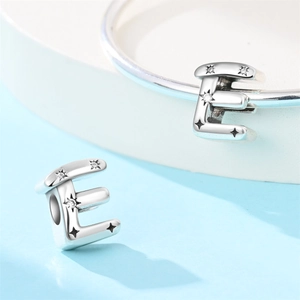 Close-up of a silver-plated letter E charm bead featuring sparkling star engravings