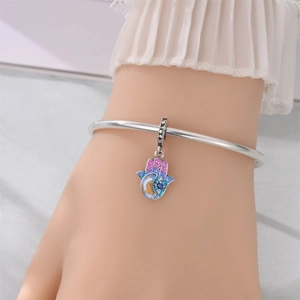 Detail of silver Hamsa Hand charm with colorful gradient enamel and crescent moon engraving