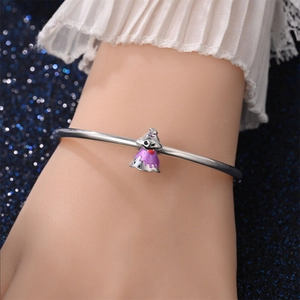 Detail van zilveren armband met paarse spookhanger op een manchet van kant