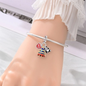 Detailed close-up of a silver charm bracelet with panda and China themed enamel pendants