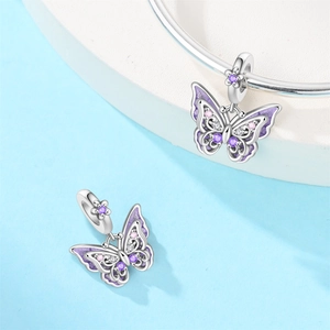 Macro detail of a purple butterfly charm with zircon accents on a silver bracelet
