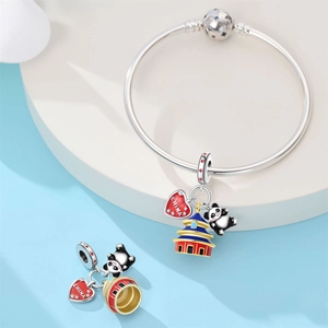 Detail of silver bracelet with panda charm, red heart China pendant and Temple of Heaven charm
