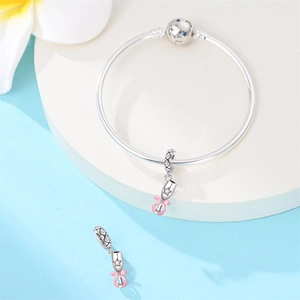 Detailed macro view of silver ballet shoes charm with pink enamel bow and crystals