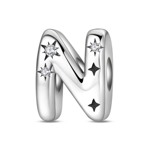 Macro shot of silver letter N charm with sparkling zircons and engraved stars for bracelets