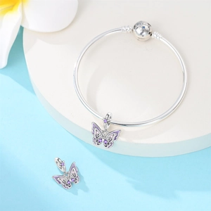 Detailed view of silver butterfly charms on a bangle with We Belong Together engraving