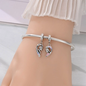 Silver bangle with couple heart charms featuring boy and girl profiles with stones