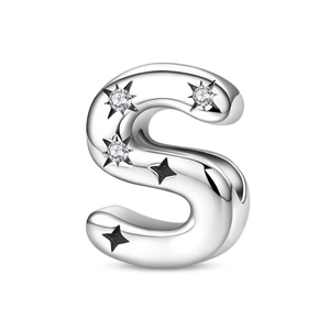 Macro detail of silver plated letter S charm with sparkling stones and star engravings