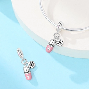 Macro detail of silver medical charms with Heal Me pill and DNA Hope engraved pendants