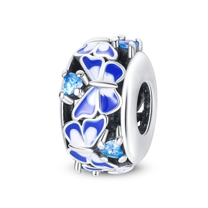 Détail d'une breloque en argent avec papillons en émail bleu et zircons en forme de cœur