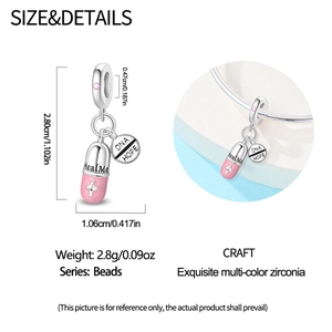 Detailed view of pink glitter enamel pill charm with Heal Me and DNA HOPE engravings