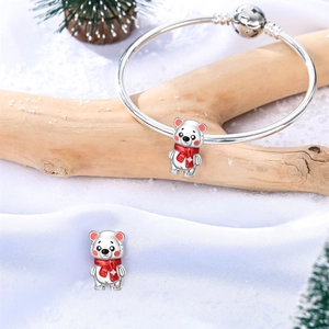 Pulsera de plata con dije de oso polar y bufanda roja sobre fondo festivo