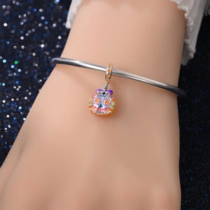 Detail van de zilveren bedelarmband met kleurrijke Halloween suikerschedel en pompoenbedel