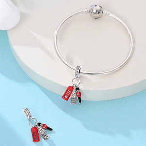 Detail of silver London charm bracelet with Big Ben and red enamel telephone booth