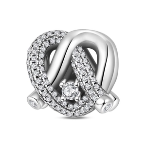 Macro shot of silver knot charm with sparkling pavé cubic zirconia and large center stone