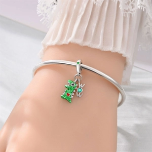 Nahaufnahme eines silbernen Armbands mit grünem Dinosaurier und WOW Edelstein Anhänger