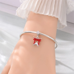 Detailed shot of silver bangle featuring Mount Fuji, Torii gate and cherry blossom charms